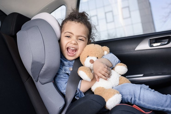 ребенок в машине с игрушкой