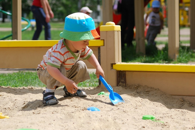 ребенок играет в песочнице